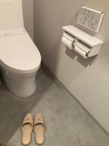 a pair of shoes in a bathroom with a toilet at Dormitory JiccA NO HOTEL in Takemiya