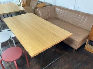 a wooden table and two chairs and a couch at Dormitory JiccA NO HOTEL in Takemiya
