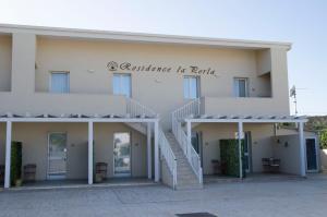a large white building with a staircase in reality at Residence La Perla - Marzamemi & Sea - Homie Livings in Marzamemi