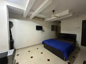 a bedroom with a blue bed and a white floor at DIAMOND PALACE Kalasipalya in Bangalore +3 photos
