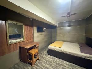 a bedroom with a bed and a desk and a mirror at DIAMOND PALACE Kalasipalya in Bangalore