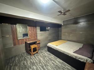 a bedroom with a bed and a table and a ceiling fan at DIAMOND PALACE Kalasipalya in Bangalore