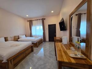 a hotel room with two beds and a television at Leego Hotel in Luang Prabang