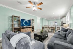 a living room with a couch and a ceiling fan at Sunset Nirvana in Panama City Beach