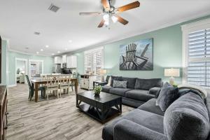 a living room with a couch and a ceiling fan at Sunset Nirvana in Panama City Beach