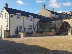 uma grande casa branca com um edifício de pedra em The Annexe em Timsbury