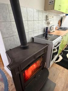 a stove with a fire in a kitchen at Vikendica Rujiste in Mostar