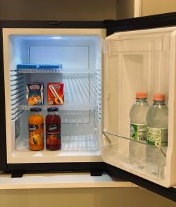 ein offener Kühlschrank mit Flaschen Saft und Milch in der Unterkunft Suite74 in Carovigno