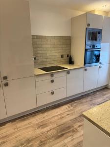 a kitchen with white cabinets and a stove top oven at The Victorian Apartment in Dundee