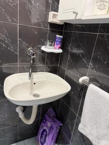 a bathroom with a white sink and a purple bag at Vikendica Rujiste in Mostar +11 photos