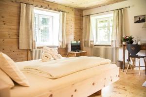 Un dormitorio con una cama y dos ventanas. en Landhaus Alger, en Immenstadt im Allgäu