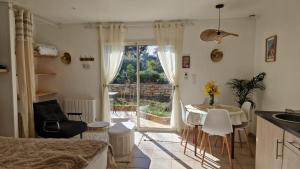 a kitchen and living room with a table and a window at Logement cosy avec piscine chauffée, jacuzzi, jardin et climatisation in Flayosc