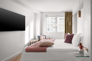 a white bedroom with a large bed and a window at White Rose Athens Residence in Athens