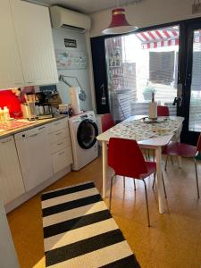 a kitchen with a table and chairs and a kitchen with a washing machine at Sunset Forest apartment in Joutsa