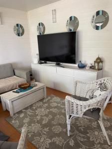 a living room with a flat screen tv on the wall at Sunset Forest apartment in Joutsa