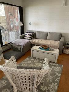 a living room with a couch and a table and chairs at Sunset Forest apartment in Joutsa