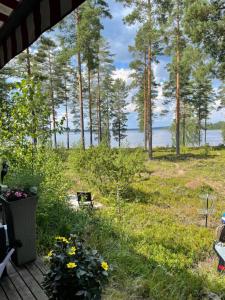 a view of a yard with trees and the water at Sunset Forest apartment in Joutsa
