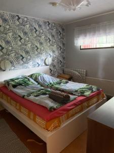 a bedroom with a bed with a blanket on it at Sunset Forest apartment in Joutsa