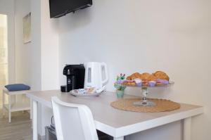 a kitchen counter with a table with a plate of bread at Residence La Perla - Marzamemi & Sea - Homie Livings in Marzamemi