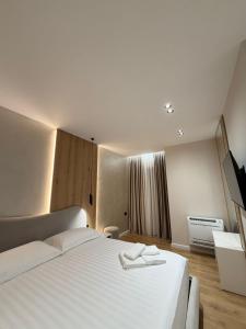 a bedroom with a large white bed and a window at Velour Boutique Hotel Durres in Durrës