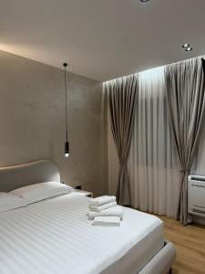 a bedroom with a large white bed and a window at Velour Boutique Hotel Durres in Durrës