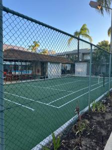 a tennis court in front of a house at Manduhra Motel Resort in Mandurah