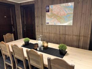 a table with potted plants and a map on the wall at Cozy Couples or Family Retreat - Hemsedal in Hemsedal