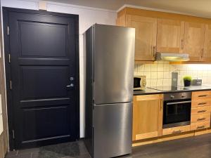a stainless steel refrigerator in a kitchen with a black door at Cozy Couples or Family Retreat - Hemsedal in Hemsedal +13 photos