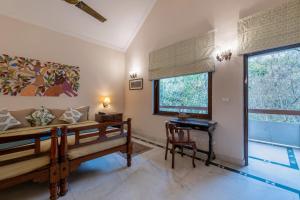 a room with two beds and a desk and a window at juSTa The Bagh, Kanha in Bhīmlāt