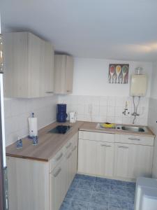 a small kitchen with white cabinets and a sink at Fewo Helga in Glowe