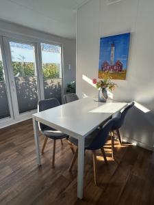 a dining room with a white table and chairs at Ferienhaus Feldblick in Fehmarn
