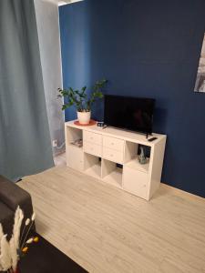 a living room with a tv on a white cabinet at Jelena Apartment 69 in Rēzekne