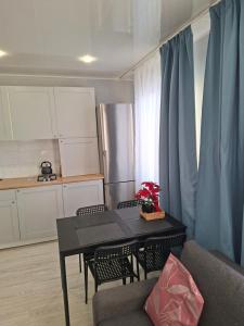 a living room with a table and a kitchen at Jelena Apartment 69 in Rēzekne