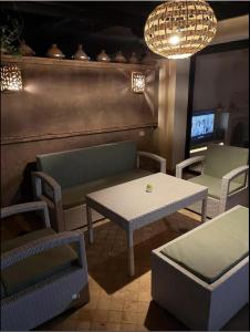 a living room with a table and chairs and a table and a couch at VILLA DETENTE PISCINE PRIVEE PROCHE D'AGADlR in Taroudant