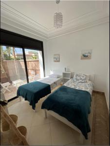 a bedroom with two beds and a large window at VILLA DETENTE PISCINE PRIVEE PROCHE D'AGADlR in Taroudant +12 photos