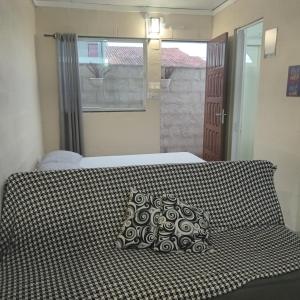 a bed with a couch with a pillow on it at Loft Caminho de Búzios in Cabo Frio