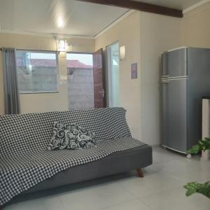 a couch in a living room with a refrigerator at Loft Caminho de Búzios in Cabo Frio