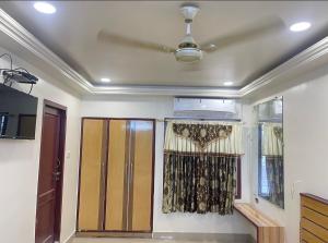 a room with a ceiling fan and a window at SangeethaInn in Ongole