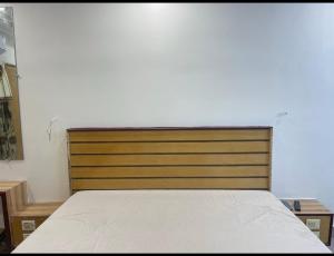 a bedroom with a bed with a wooden headboard at SangeethaInn in Ongole