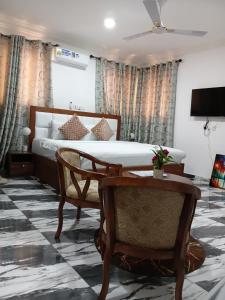 a bedroom with a bed and a table and chairs at First HR Hotel in Prampram