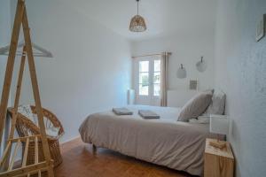 a white bedroom with a bed and a ladder at Le gîte de Agnes in Fronsac