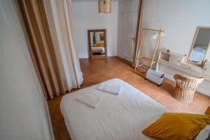 a bedroom with a white bed and a mirror at Le gîte de Agnes in Fronsac +2 photos
