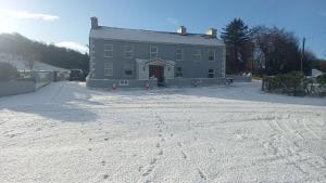 a large gray house in the snow with a driveway at The Serendipity Suite - A Scenic Countryside Hideaway in Letterkenny +5 photos