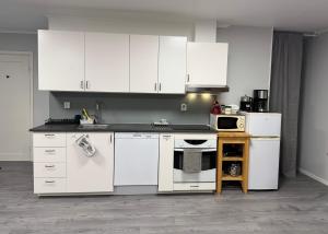 a kitchen with white appliances and white cabinets at Green Forest Oasis & Sea in Strömstad