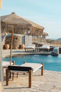 a pool with chairs and umbrellas next to a pool at Santa Maria Hotel in Elia Beach