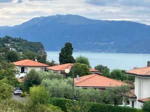 a view of a house with a lake and mountains at Casale el galet in Moniga