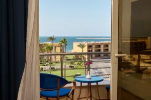 a balcony with a table and chairs and a view of the ocean at Helnan Mamoura Hotel & Events Center in Alexandria
