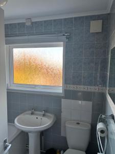 a bathroom with a sink and a toilet and a window at Sea Rose ,Broadstairs in Broadstairs