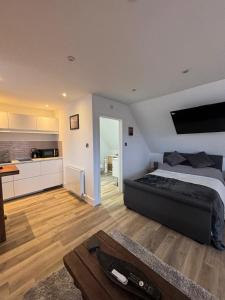 a bedroom with a large bed and a kitchen at Tollgate Annexe in Ashford