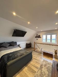 a bedroom with a bed and a flat screen tv on the wall at Tollgate Annexe in Ashford